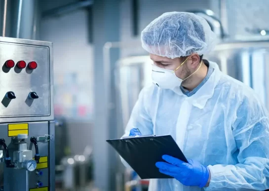 technologist-expert-protective-uniform-with-hairnet-mask-taking-parameters-from-industrial-machine-food-production-plant_342744-1176