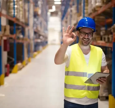 warehouse-worker-standing-large-storage-center-showing-ok-hand-gesture-satisfied-delivering-goods_342744-1526